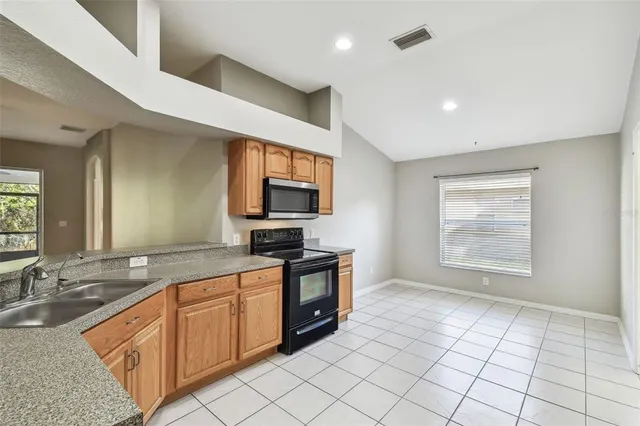 a large kitchen with a sink and a stove top oven
