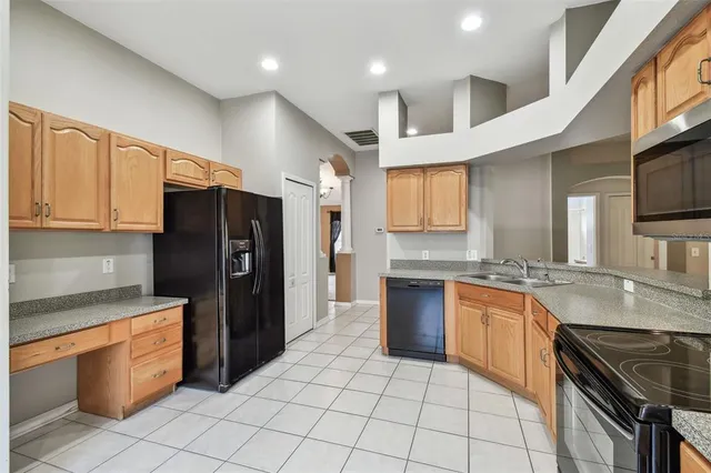a kitchen with stainless steel appliances granite countertop a refrigerator a sink and dishwasher