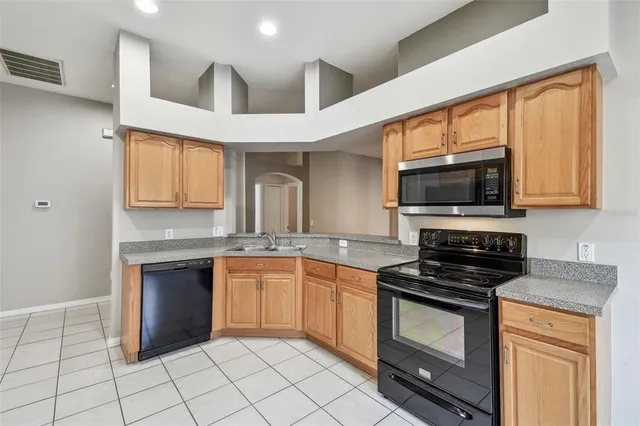a kitchen with stainless steel appliances granite countertop a stove a sink and a microwave