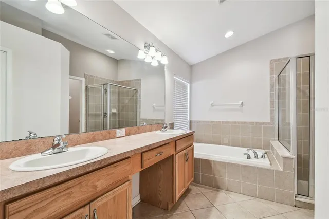 a bathroom with a granite countertop bathtub a sink and a large mirror