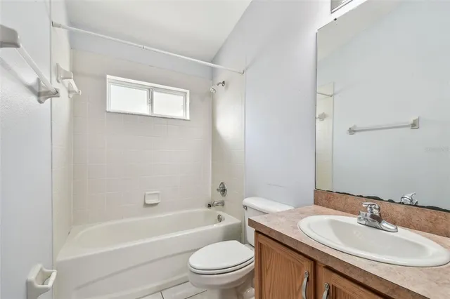 a bathroom with a granite countertop toilet a sink and a bathtub