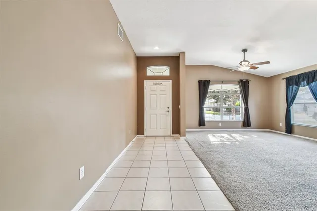 a view of a hallway with wooden floor and a living room