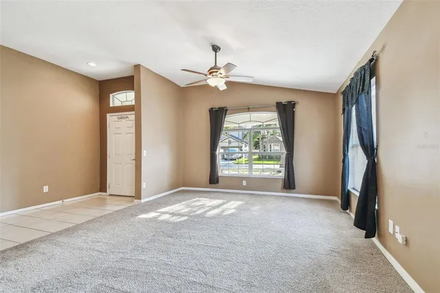 a view of a livingroom with a ceiling fan and window