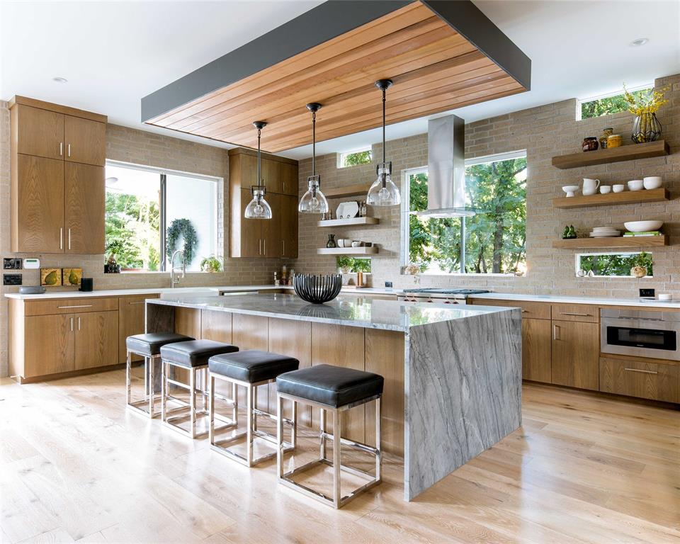 5531 Goodwin Avenue Dallas, TX 75206 - Photo 14 of 39 Kitchen with open shelves, a kitchen island, backsplash, wood finish cabinets, and a breakfast bar
