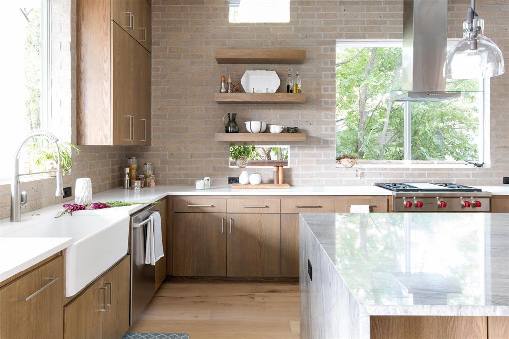 5531 Goodwin Avenue Dallas, TX 75206 - Photo 17 of 39 Kitchen featuring open shelves, light stone counters, light wood finished floors, stainless steel appliances, and modern cabinets