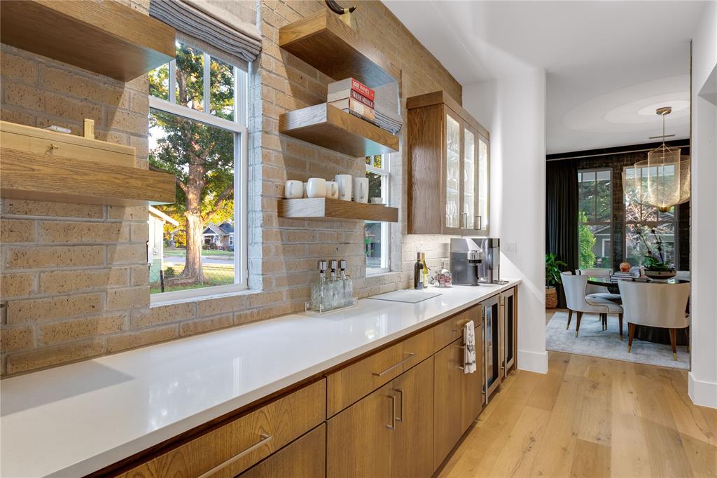 5531 Goodwin Avenue Dallas, TX 75206 - Photo 19 of 39 Kitchen featuring open shelves, wood finish cabinetry, light wood-style flooring, tasteful backsplash, and light stone countertops