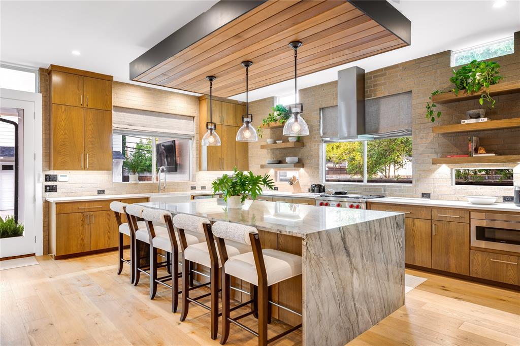 5531 Goodwin Avenue Dallas, TX 75206 - Photo 2 of 39 Kitchen featuring wood finish cabinets, tasteful backsplash, open shelves, and light wood finished floors