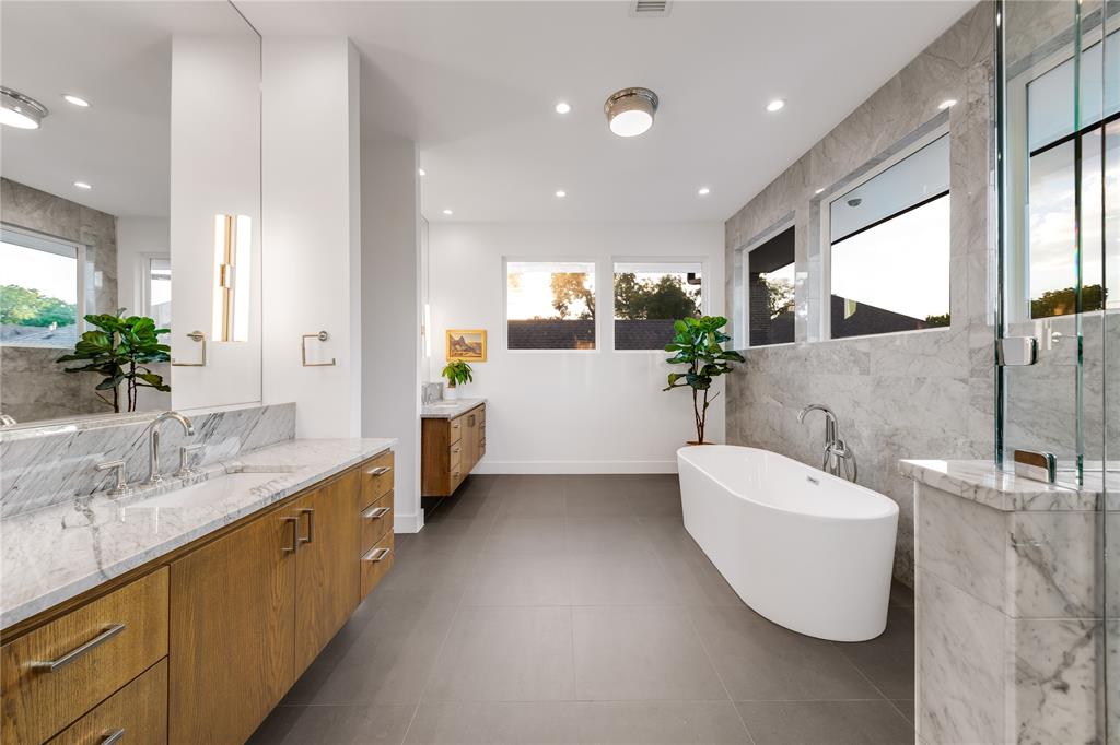 5531 Goodwin Avenue Dallas, TX 75206 - Photo 25 of 39 Bathroom with tile walls, two vanities, a soaking tub, a marble finish shower, and dark tile patterned floors