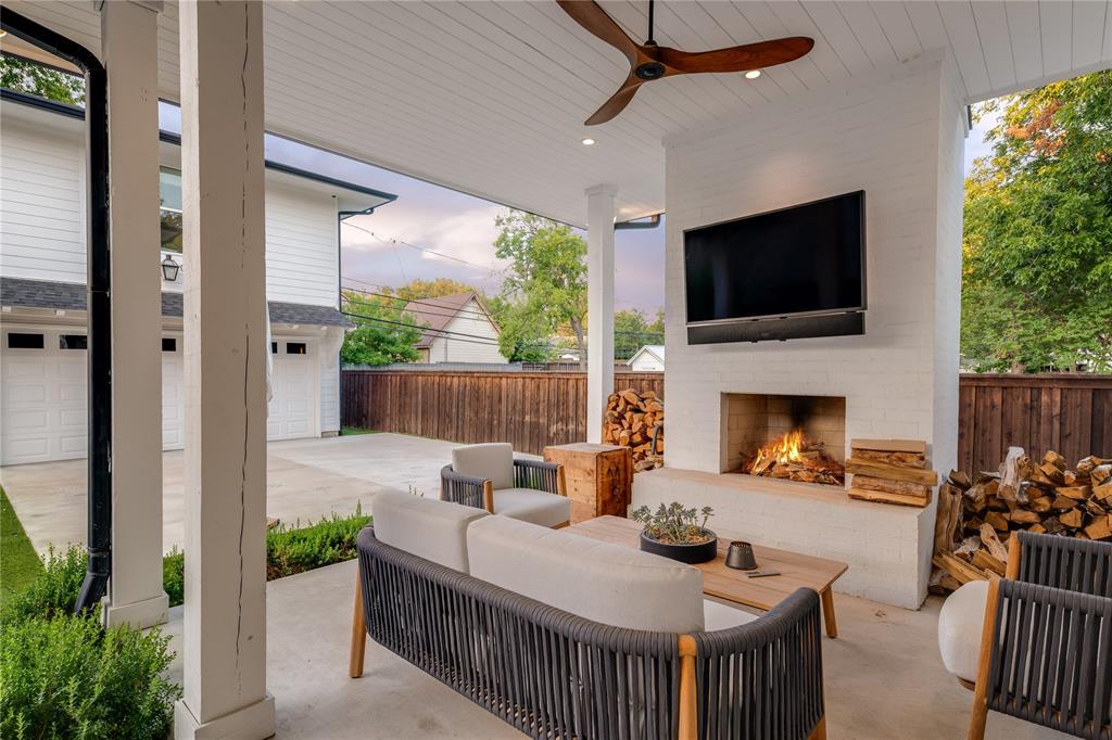 5531 Goodwin Avenue Dallas, TX 75206 - Photo 33 of 39 View of patio / terrace with an outdoor living space with a fireplace, a ceiling fan, radiator, and driveway
