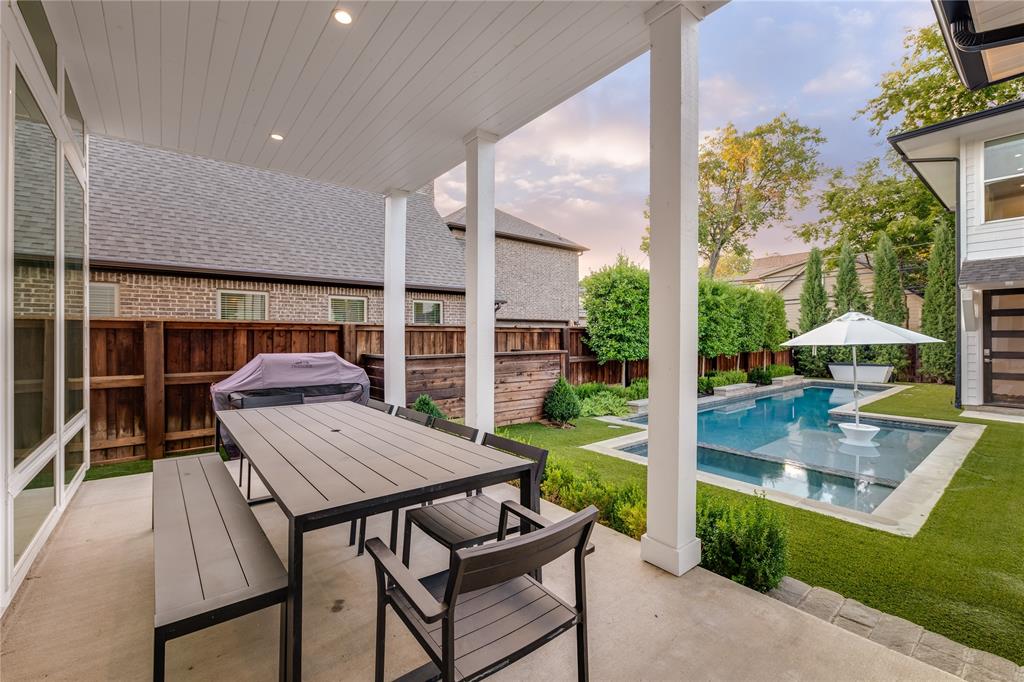 5531 Goodwin Avenue Dallas, TX 75206 - Photo 34 of 39 Patio terrace at dusk with outdoor dining space, a patio, and a fenced backyard