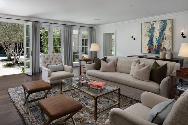 a living room with furniture a large window and a rug