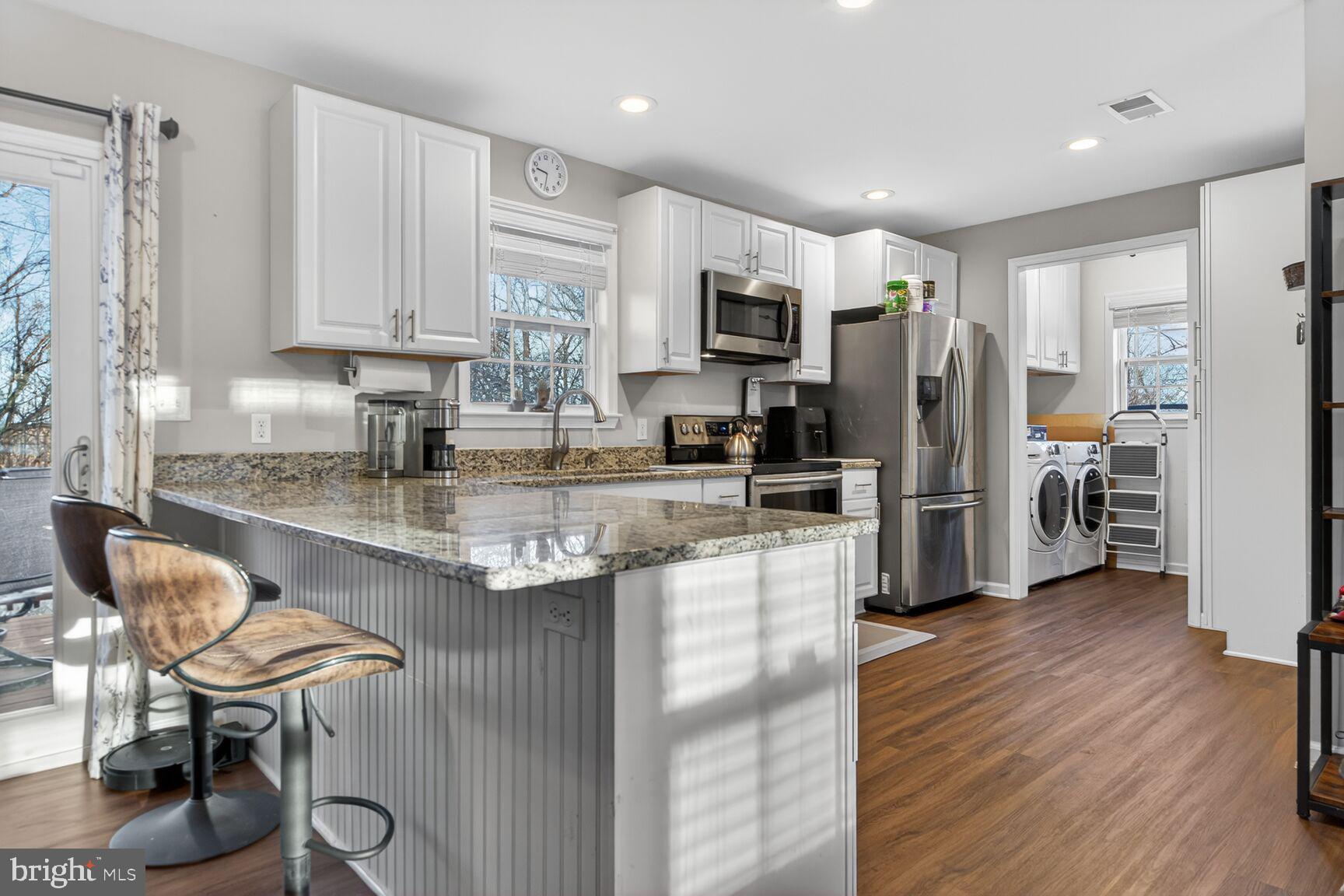 599 Widewater Road Stafford, VA 22554 - Photo 25 of 27 a kitchen with stainless steel appliances granite countertop a table chairs refrigerator and a sink
