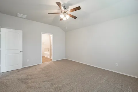 an empty room with a chandelier fan and windows