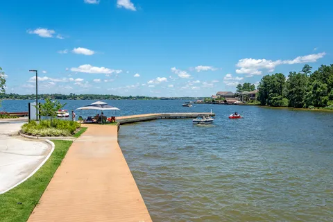 a view of swimming pool with seating space and trees in the background