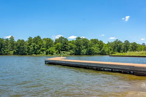 a view of a lake with outdoor space and trees in the background