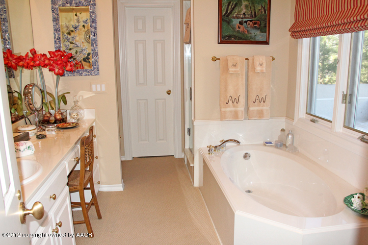 8 Edgewater Drive Amarillo, TX 79106 - Photo 15 of 41 a bathroom with a tub a sink and a window