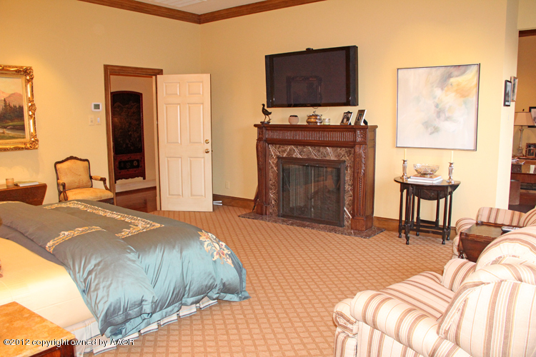 8 Edgewater Drive Amarillo, TX 79106 - Photo 19 of 41 a bedroom with a bed and a fireplace
