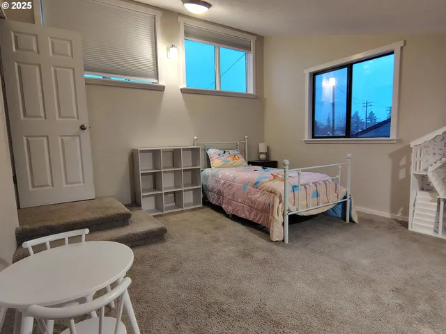 a bedroom with a bed a table and chair