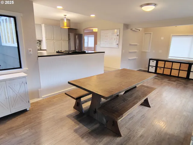 a kitchen with stainless steel appliances wooden floor dining table and chairs