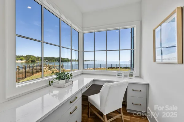 a large white kitchen with kitchen island a large island a sink stainless steel appliances and a chandelier