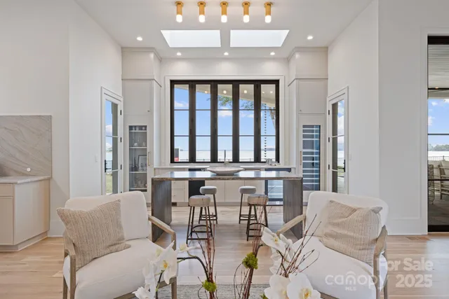 a view of a dining room with furniture a chandelier and a window