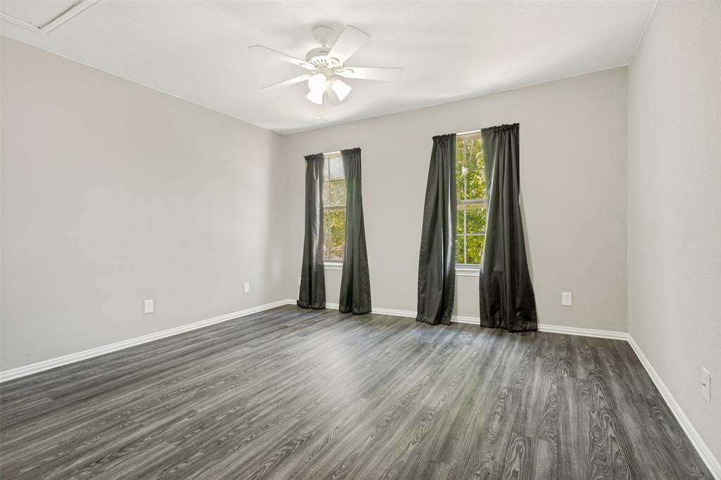 1228 Concho Drive Benbrook, TX 76126 - Photo 29 of 39 Spacious room featuring light gray walls, wood-finish flooring, and two windows