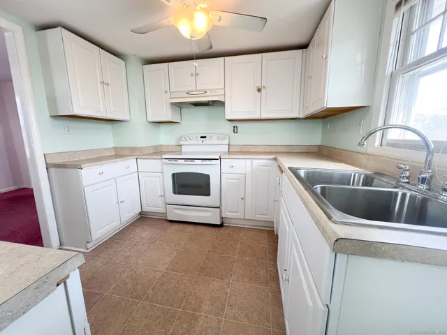 a kitchen with white cabinets and white appliances