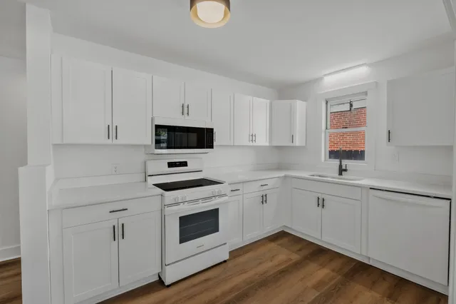 an empty room with wooden floor and cabinet