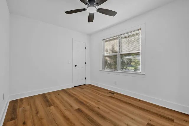 a view of empty room with wooden floor