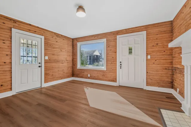 an empty room with windows and fireplace