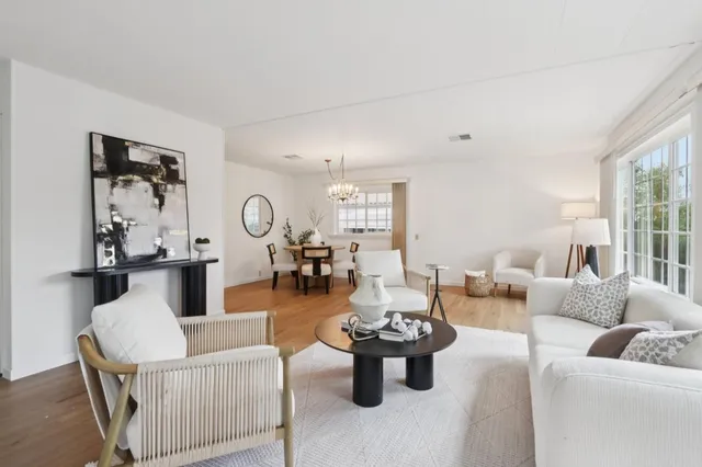 a living room with furniture a rug and a large window