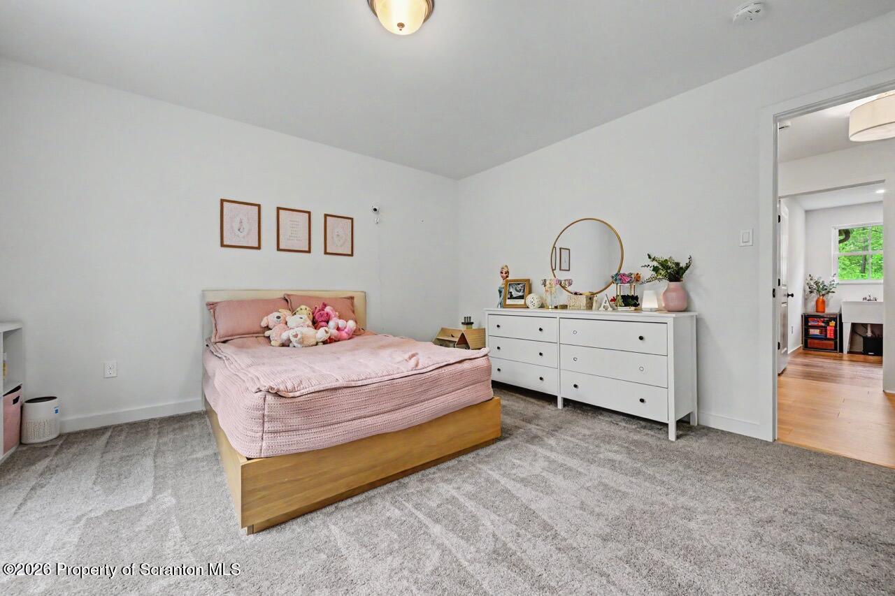 100 Highland Road Moscow, PA 18444 - Photo 58 of 85 a spacious bedroom with a bed and a table