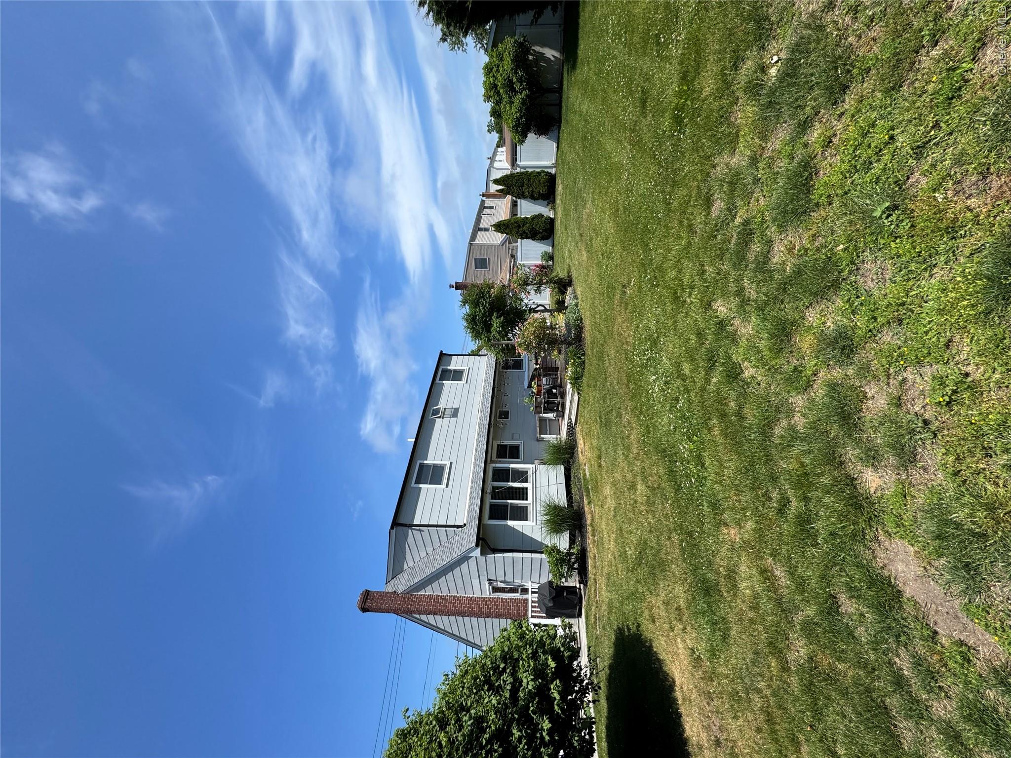 338 Carnation Road West Islip, NY 11795 - Photo 9 of 18 Expansive backyard featuring a large grass area, a patio space, and mature perimeter trees