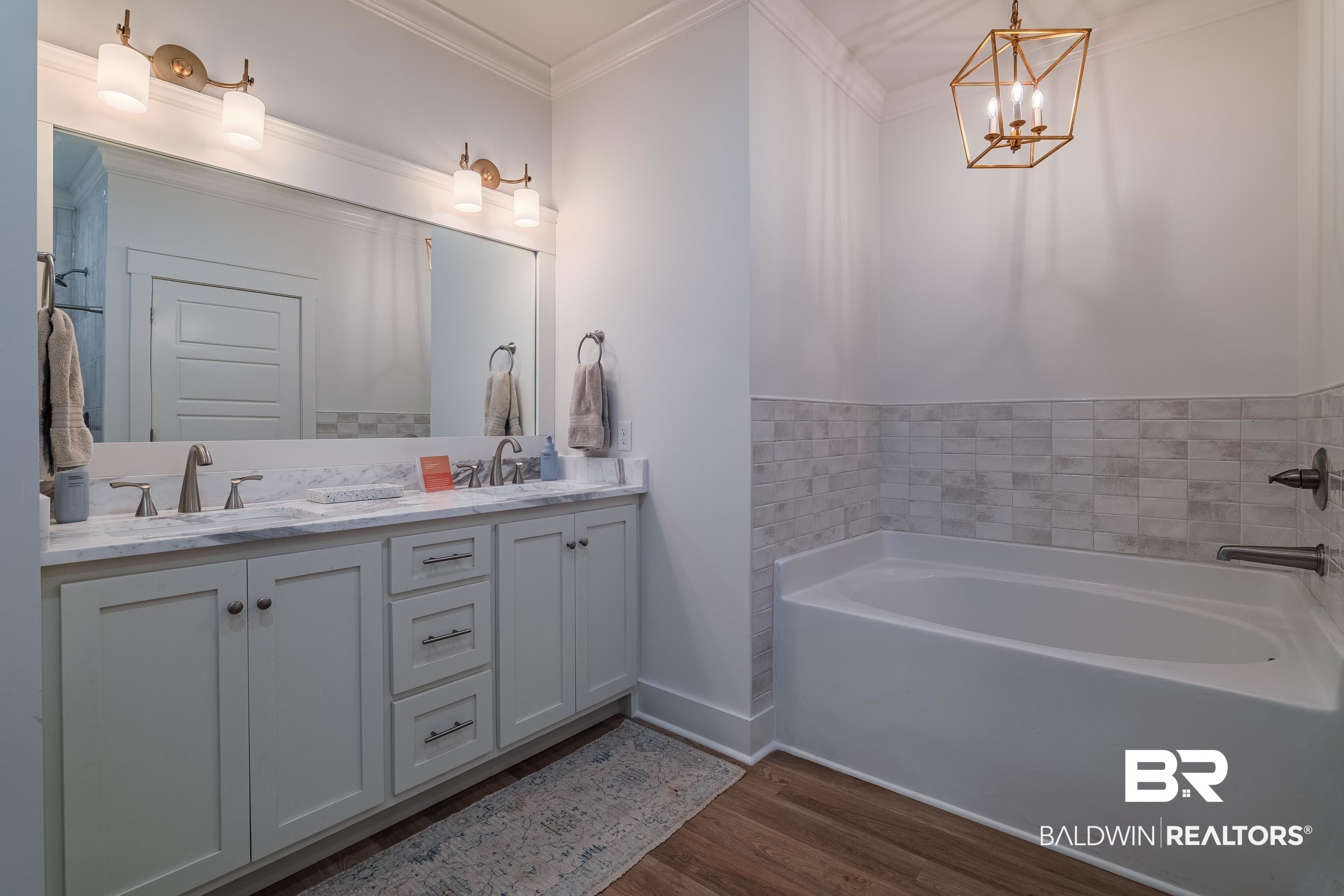 19121 Boothe Road Fairhope, AL 36532 - Photo 18 of 41 Bathroom with double vanity, dark wood-style floors, crown molding, a bath, and hanging lights