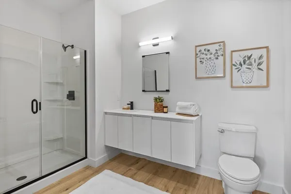 a bathroom with a toilet a sink a shower and mirror