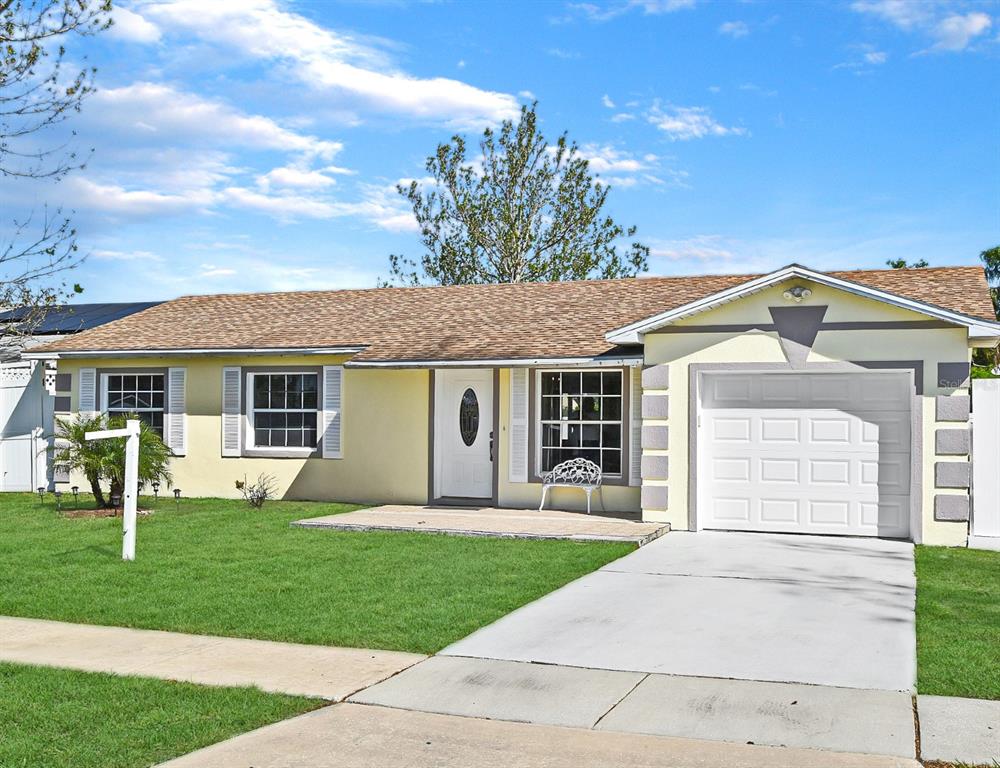 a front view of a house with a garden and trees