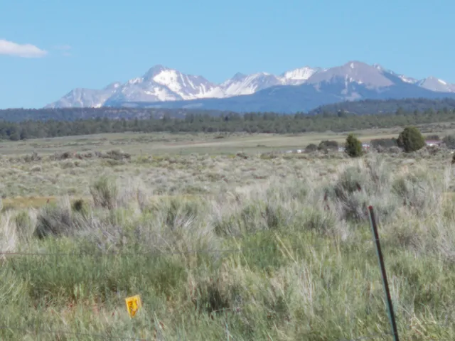 a view of mountain with sunset in background