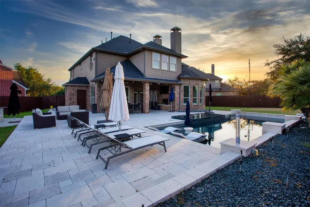 a view of a house with backyard water fountain and sitting area