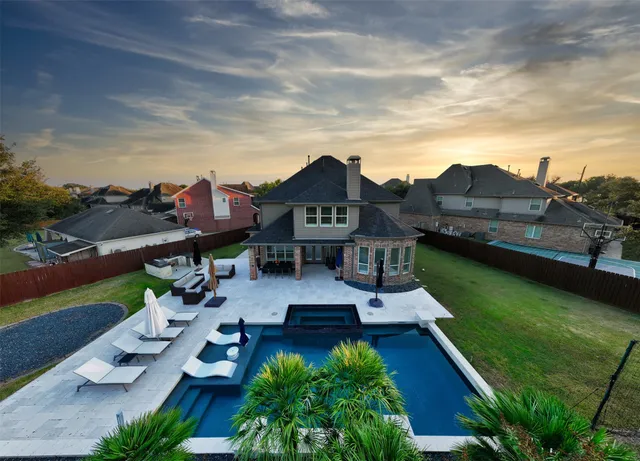 an aerial view of a house with swimming pool garden and patio