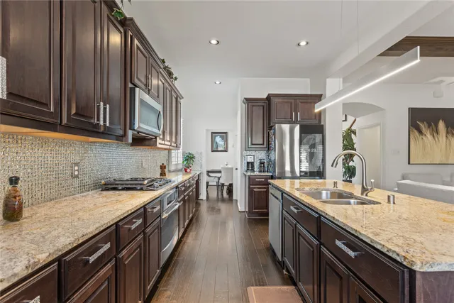 a kitchen with stainless steel appliances granite countertop sink stove top oven and cabinets