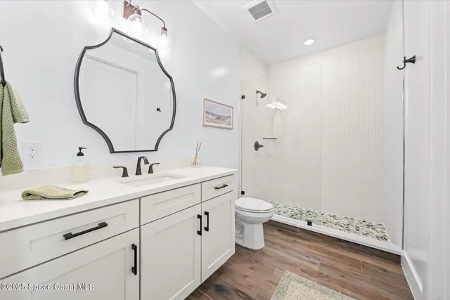 a view of a hallway with wooden floor and living room