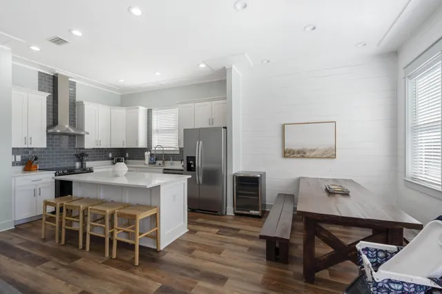 a kitchen with a dining table chairs refrigerator and cabinets