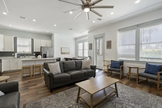 a living room with furniture kitchen view and a large window