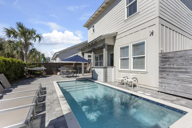 a view of house with yard outdoor seating and swimming pool