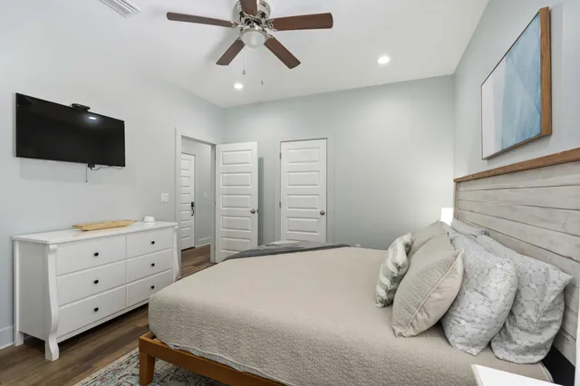a bedroom with a large bed and a flat tv screen on dresser