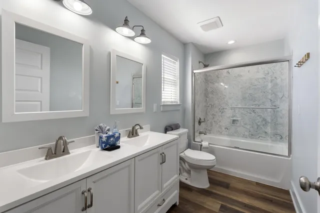 a bathroom with a double vanity sink toilet and shower