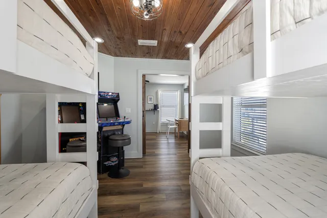 a bedroom with a bed and a flat tv screen on wall