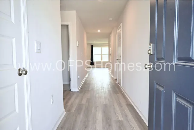 a view of a hallway with wooden floor and staircase