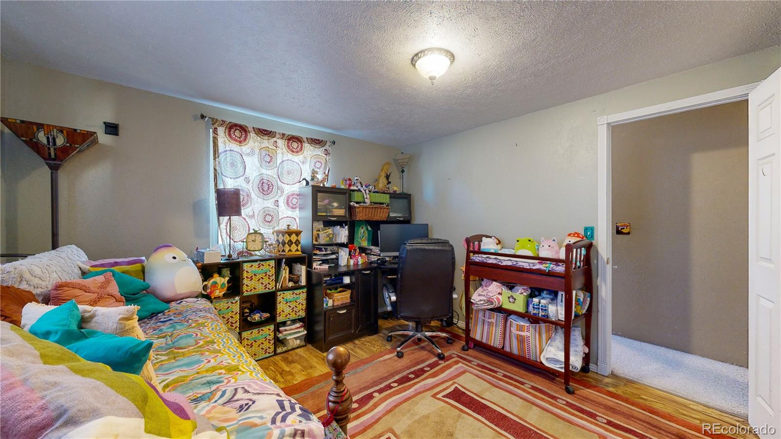708 Independence Drive Longmont, CO 80504 - Photo 17 of 40 a living room with furniture a bookshelf and a window