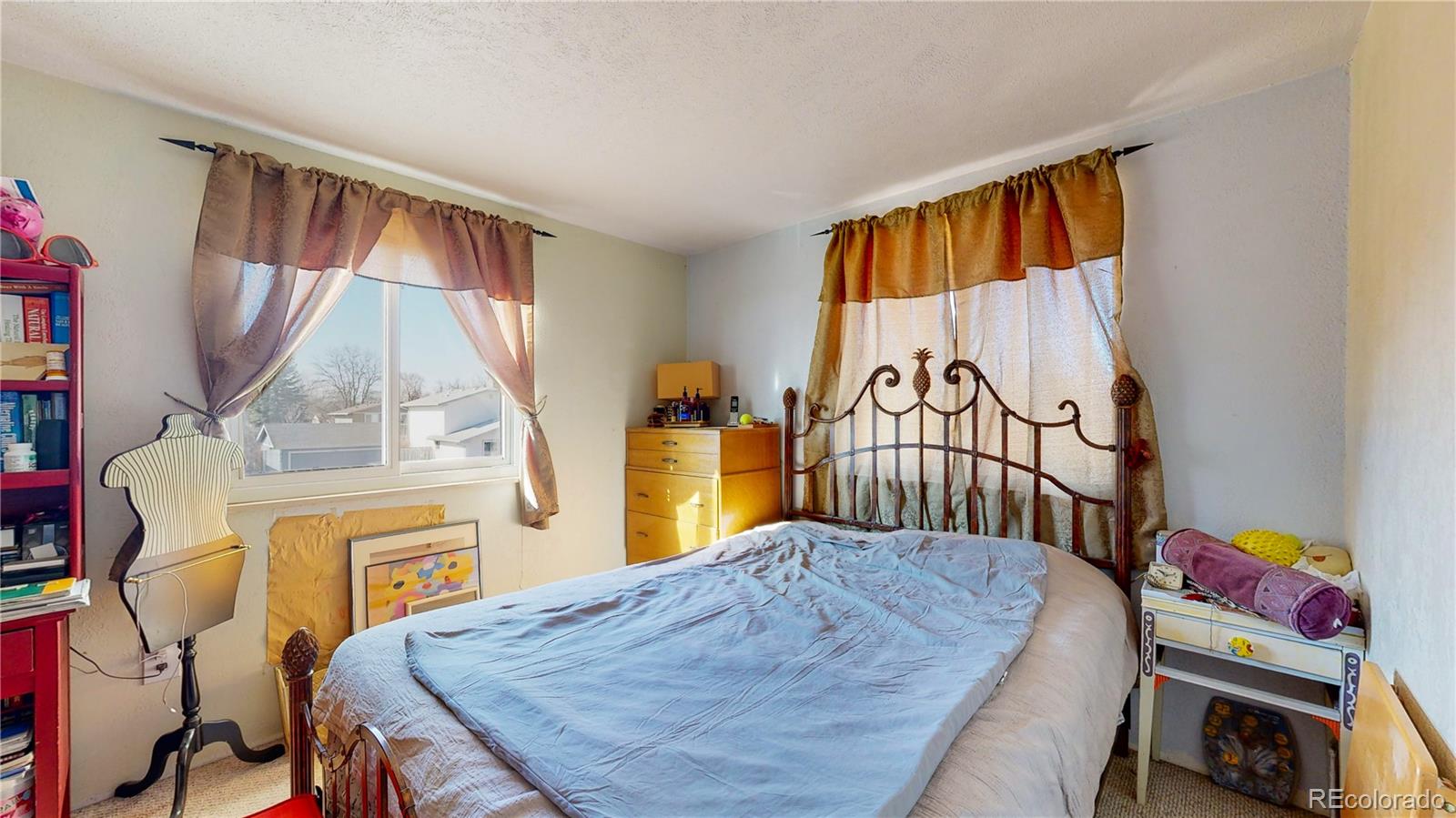 708 Independence Drive Longmont, CO 80504 - Photo 20 of 40 a bedroom with a bed a dresser and a book shelf